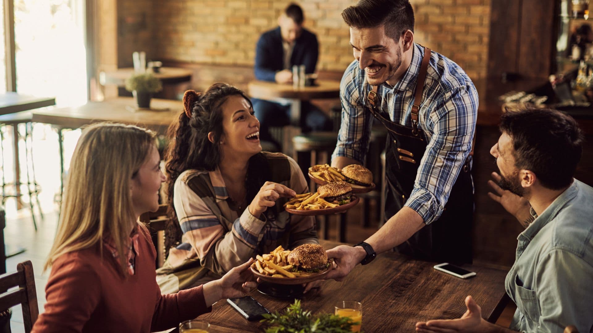 Kellner bringt Burger an den Tisch