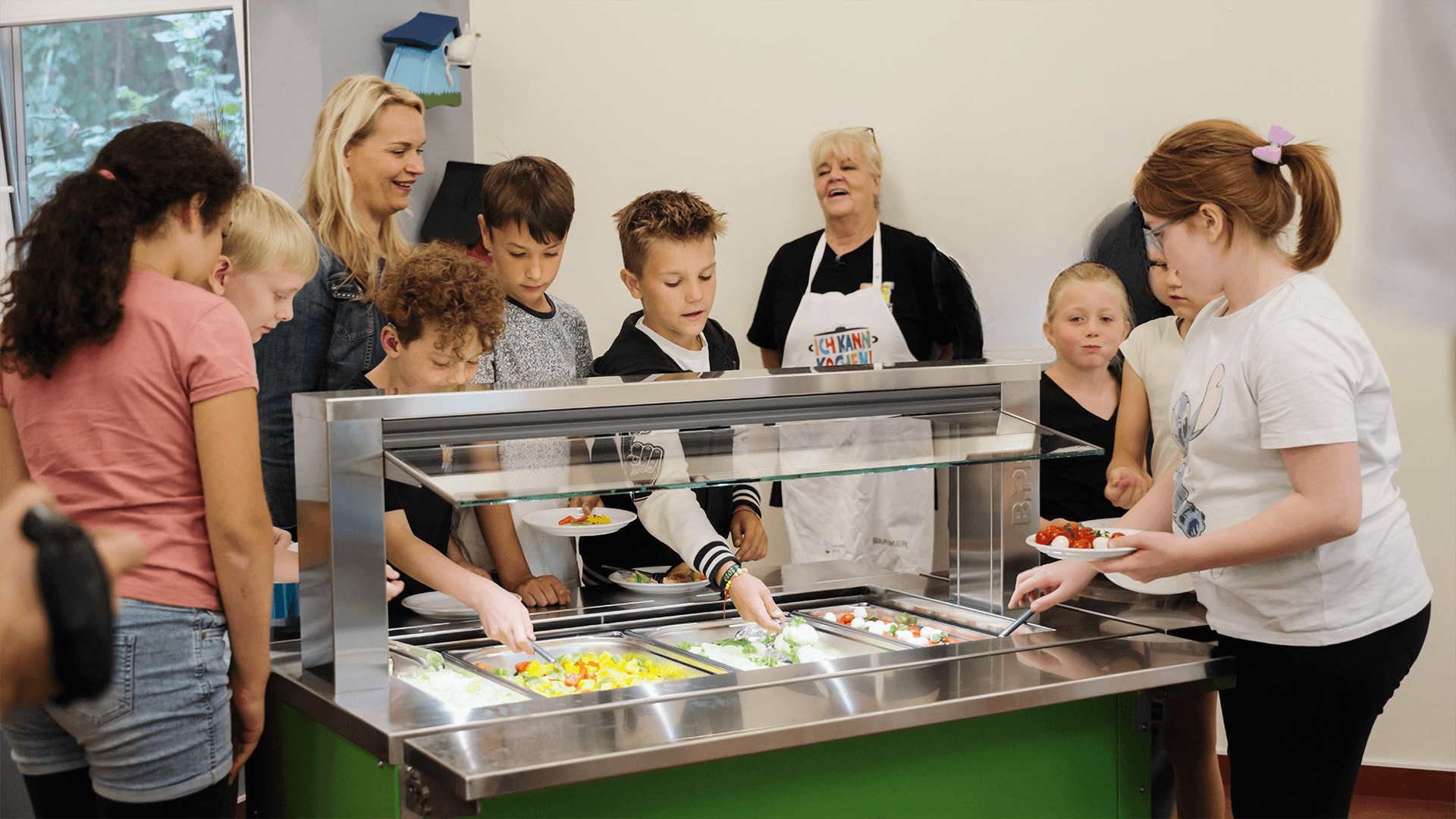 Niños durante la entrega de una barra de ensaladas BASIC LINE Kids como donación de BPro