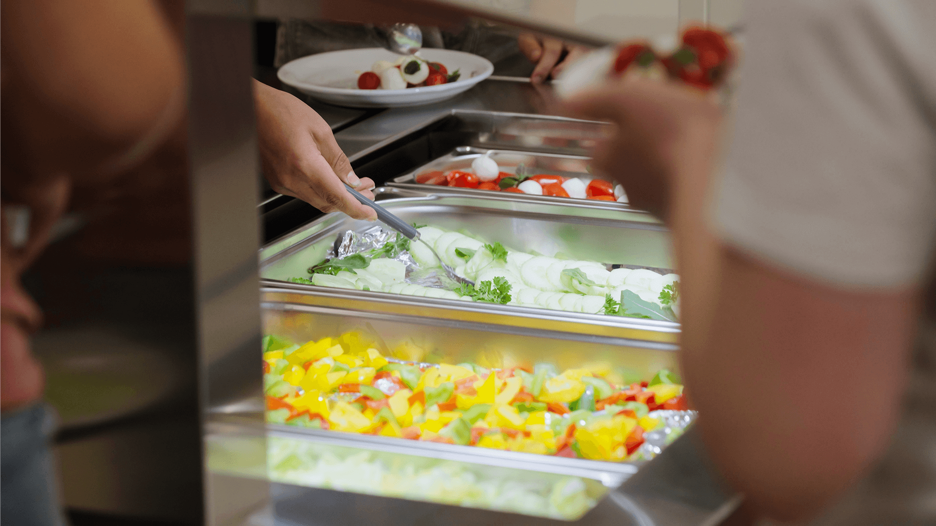 Mostrador de ensaladas en uso durante la entrega de un mostrador de ensaladas BASIC LINE Kids como donación de BPro