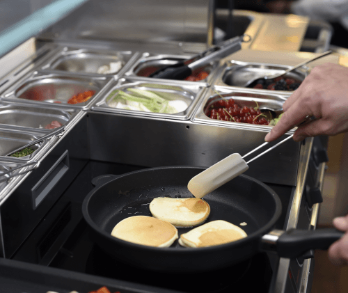 Pancakes werden auf Kochstation zubereitet